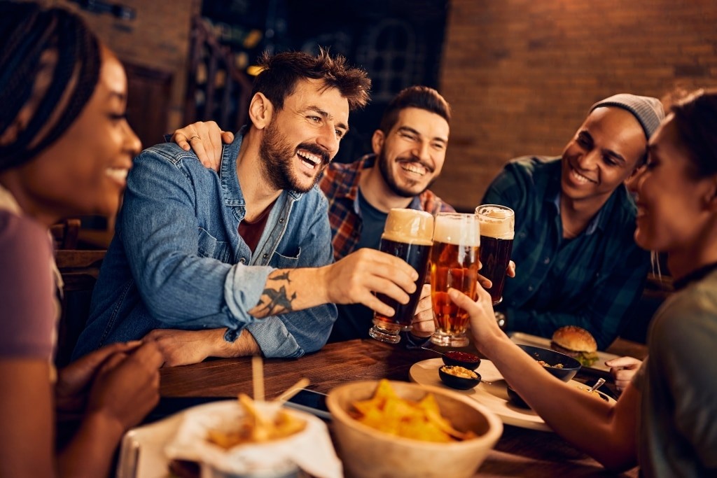Group,Of,Young,Cheerful,People,Toasting,While,Drinking,Beer,In